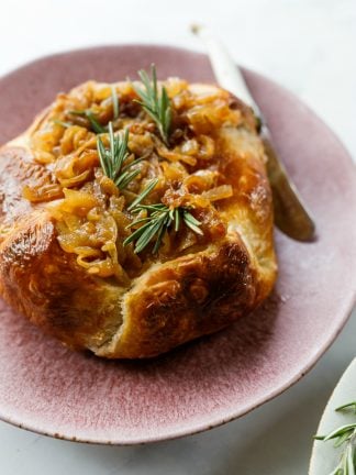 Onion Brie En Croute with knife on serving plate