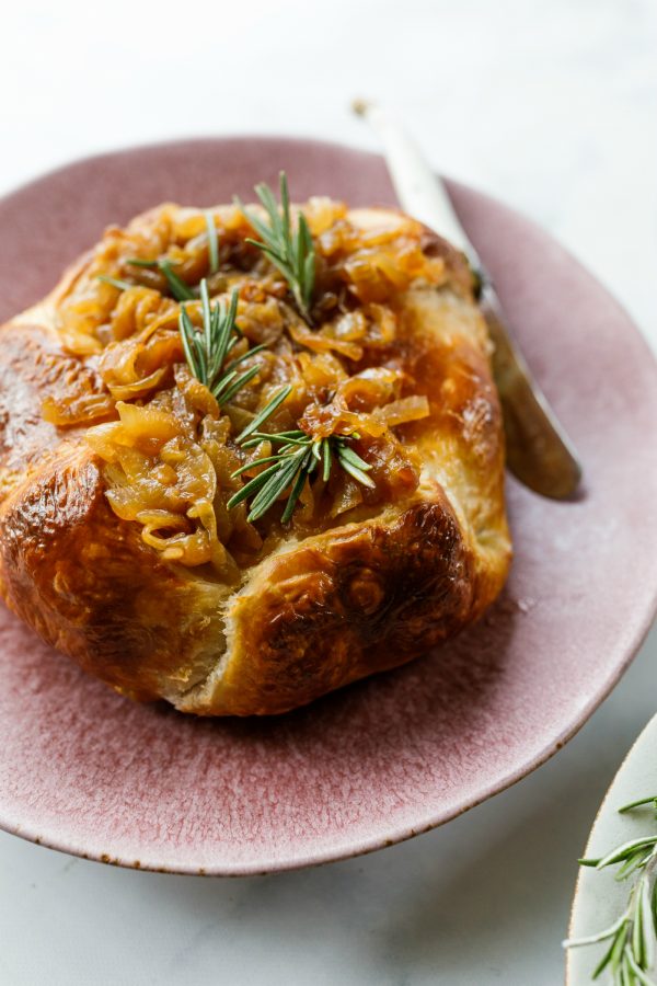 Onion Brie En Croute with knife on serving plate