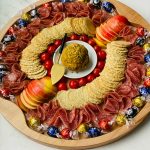 a board with Bacon Gouda Pistachio Cheese Ball in the center