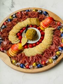 a board with Bacon Gouda Pistachio Cheese Ball in the center