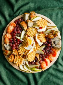 round wood tray with breakfast foods and waffle egg sandwiches