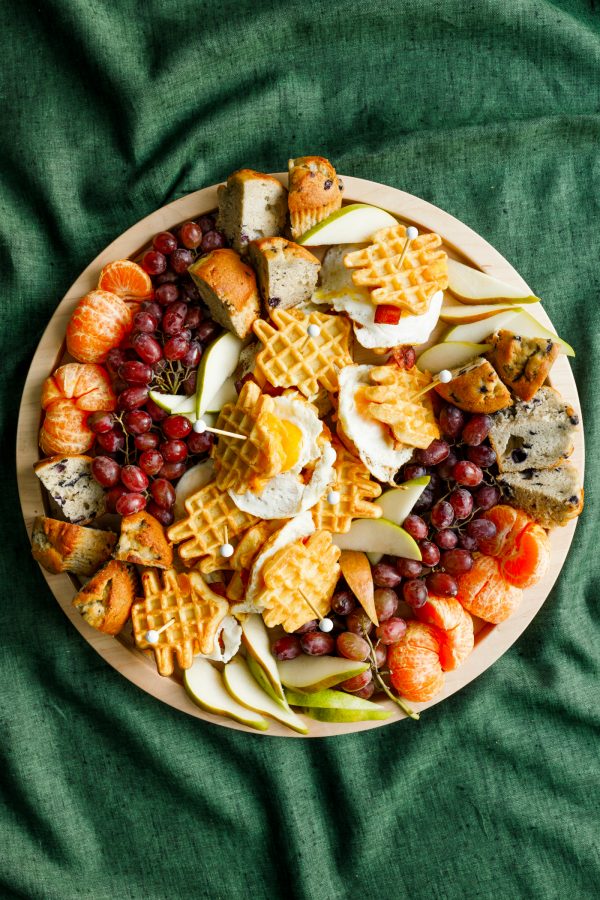 round wood tray with breakfast foods and waffle egg sandwiches