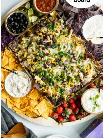 a nacho board with chips and dips and taboo game