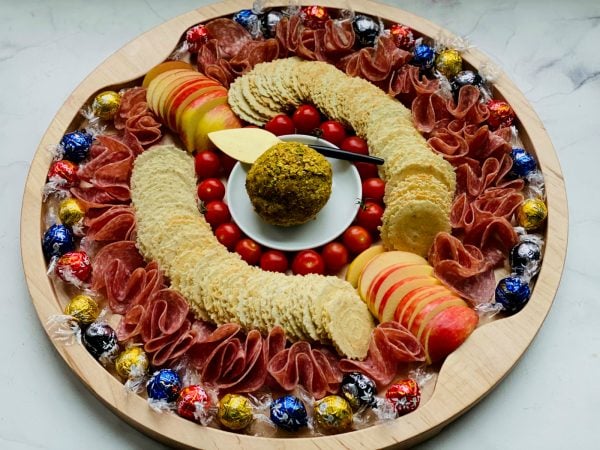 a round charcuterie board with Bacon Gouda Pistachio Cheese Ball