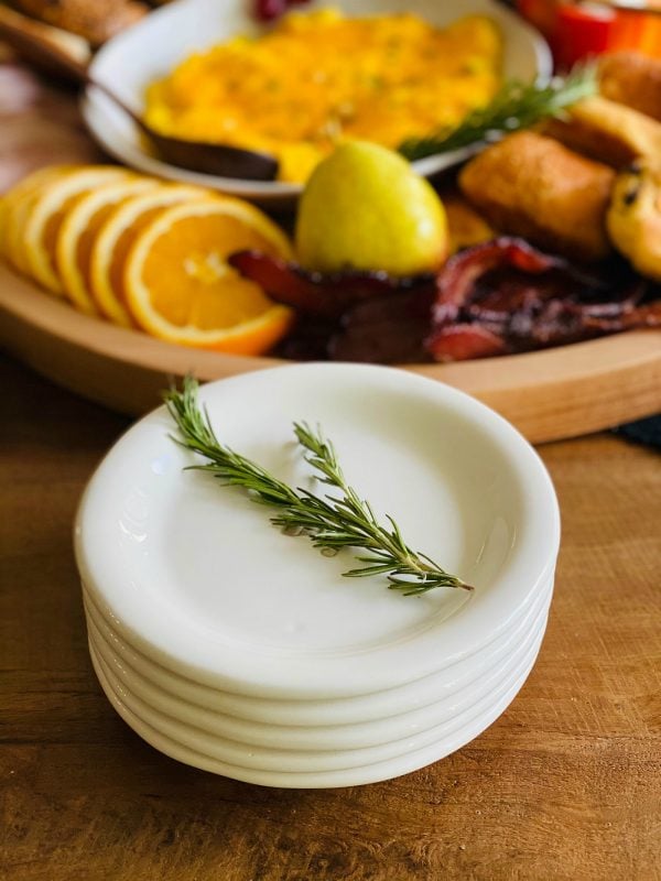 stack of white dishes (with sprig of rosemary)