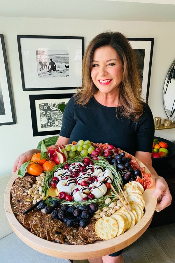 woman holding a holiday Winter Burrata Charcuterie Board