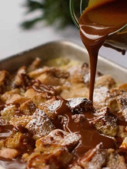 pouring caramel sauce over bread pudding with pears