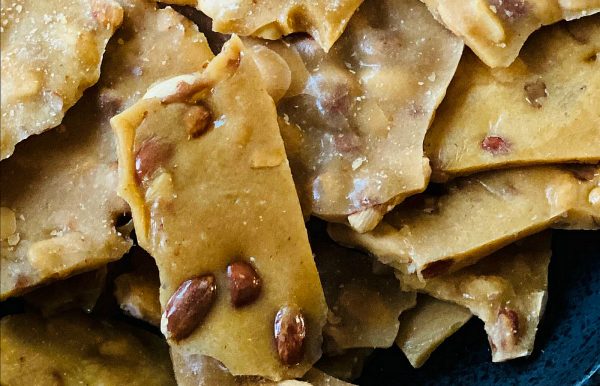 close up piece of peanut brittle with dark peanuts