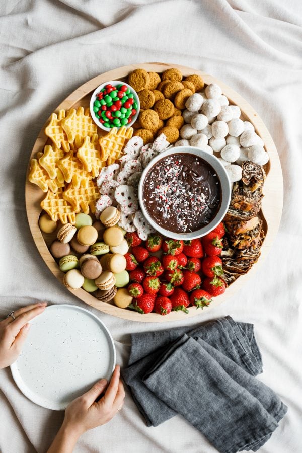 holding plates to serve with a round christmas dessert board