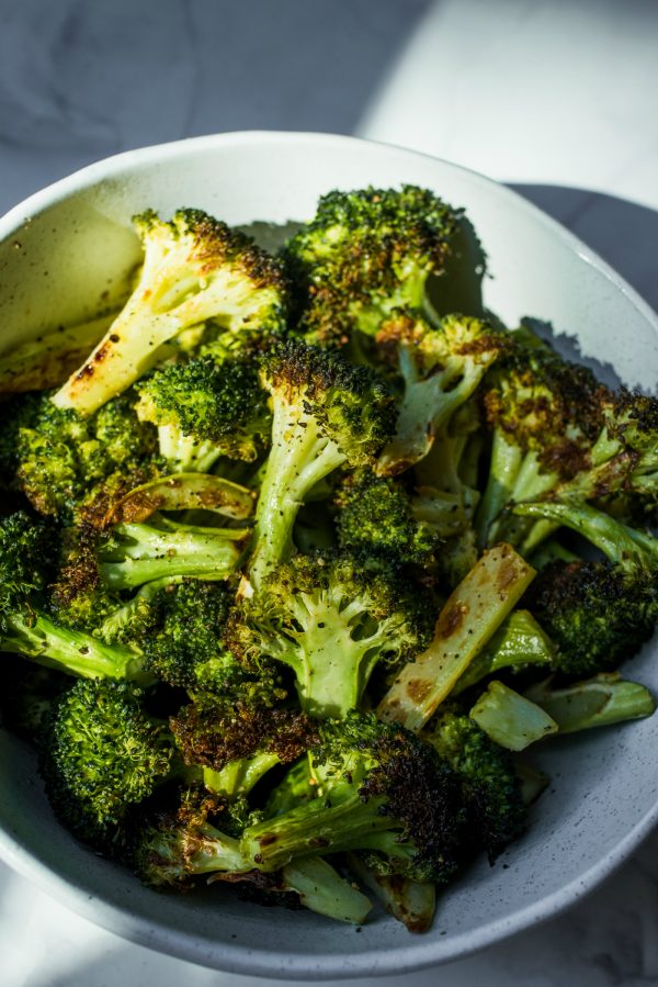 beautiful white bowl of oven roasted broccoli