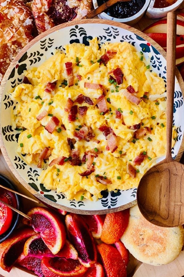 round bowl of scrambled eggs with wood spoon