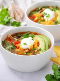 Slow Cooker Chicken Enchilada Soup garnished with avocado and sour cream