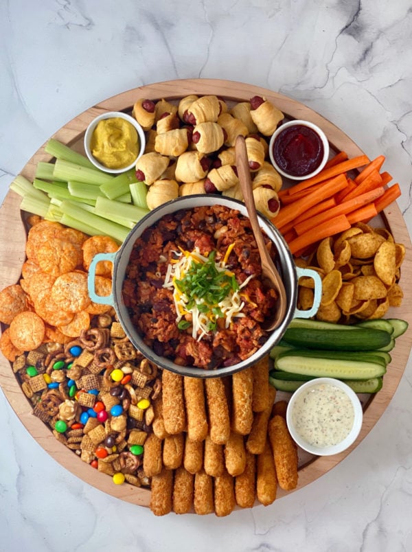 round board with chili and game day snacks