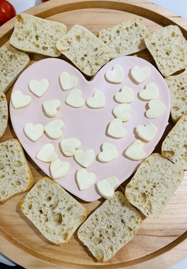 making Heart Caprese Sandwich Board with mozzarella cheese
