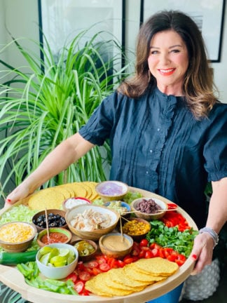 woman holding a chicken tostada board