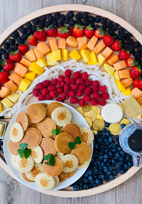 fruit shaped like a rainbow on a breakfast board