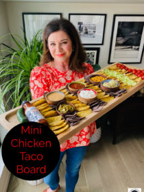 woman holding mini chicken tacos