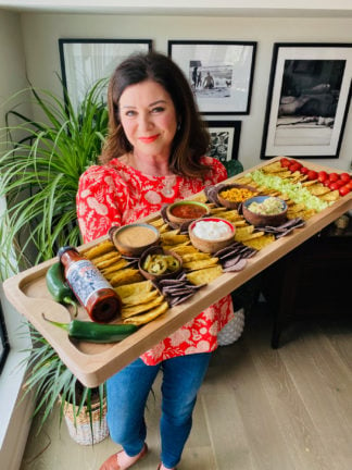 woman holding a chicken taco board