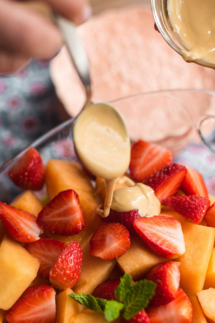 adding a vanilla dressing to a fruit salad