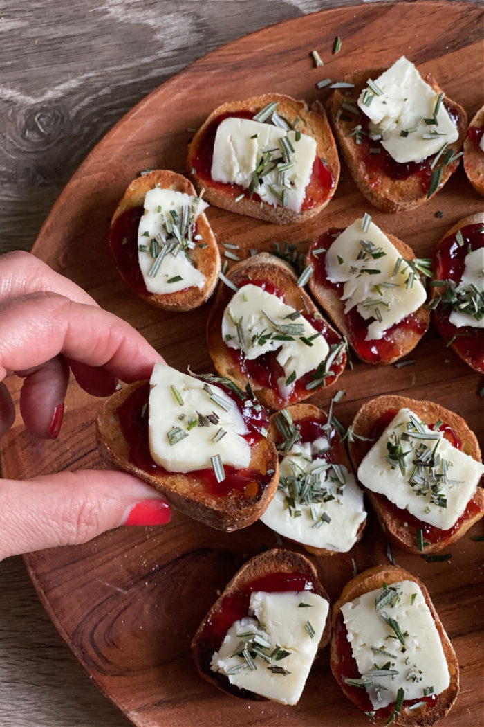 taking a bite of brie crostini