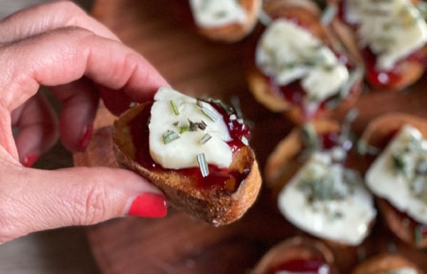 holding a brie strawberry crostini