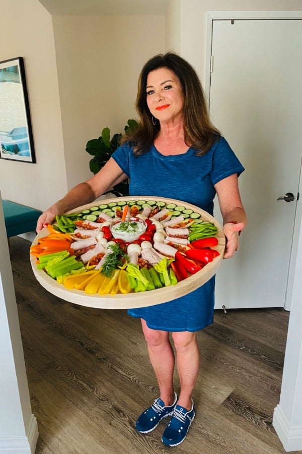 woman holding a round zero point charcuterie board