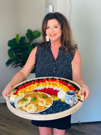 woman holding an Easy Rainbow Breakfast Board