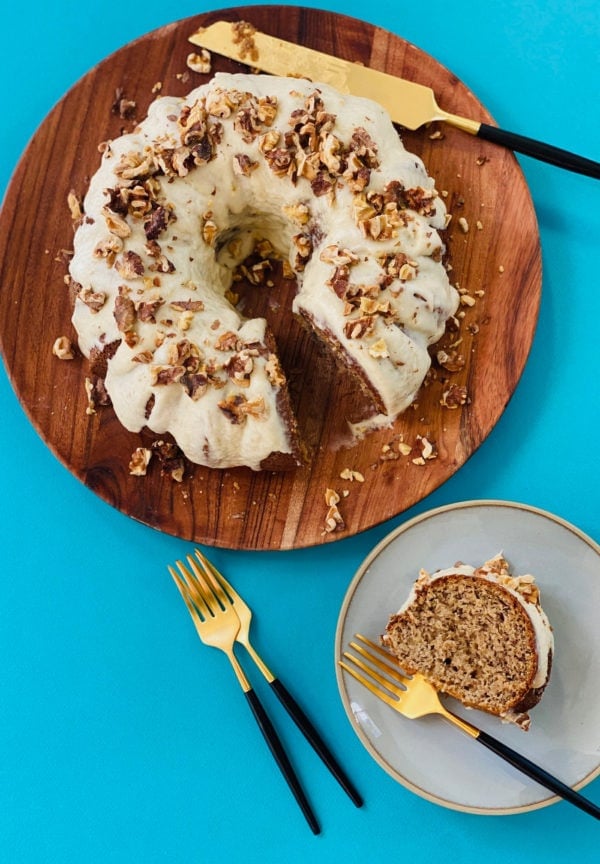 Sour Cream Banana Bundt cake on a wood plate with a slice on a plate with fork