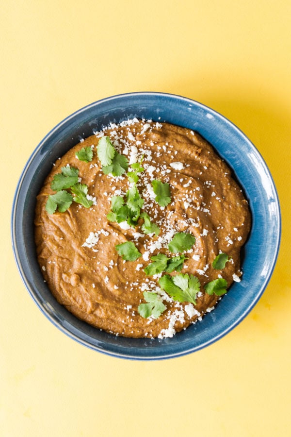 blue round bowl of Homemade Refried Pinto Beans