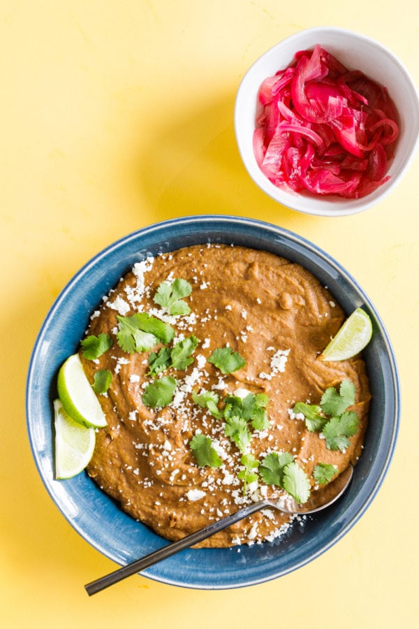 Homemade Refried Pinto Beans with small bowl of red onions