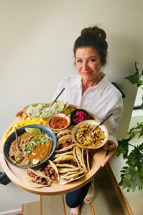 woman holding an epic steak taco board