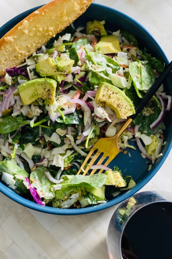 salad in a bag with avocado and glass of wine