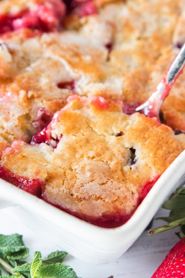 cutting into a Best Strawberry Cobbler
