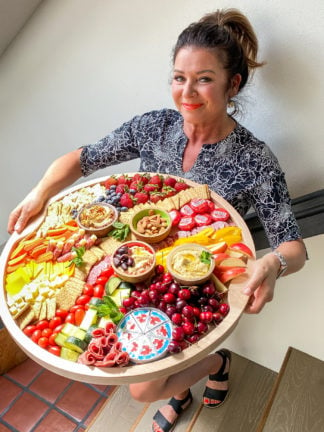 woman holding the Ultimate Classic Hummus Board