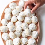 taking a Mexican Wedding Cookie off a plate