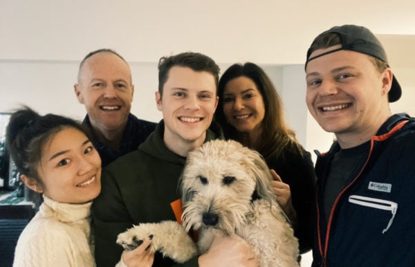 family together holding a whoodle dog