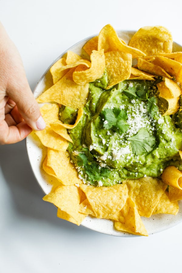 taking a bite of chip with Best Avocado Salsa Verde