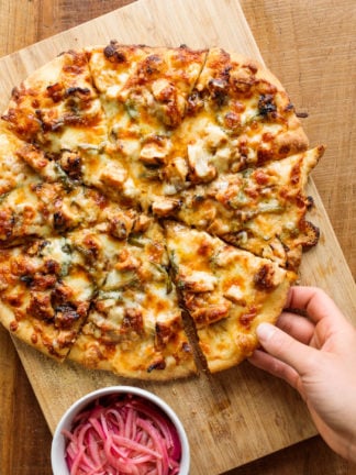 taking a piece of Homemade BBQ Chicken Pizza