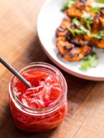 jar of pickled red onions and plate of chicken