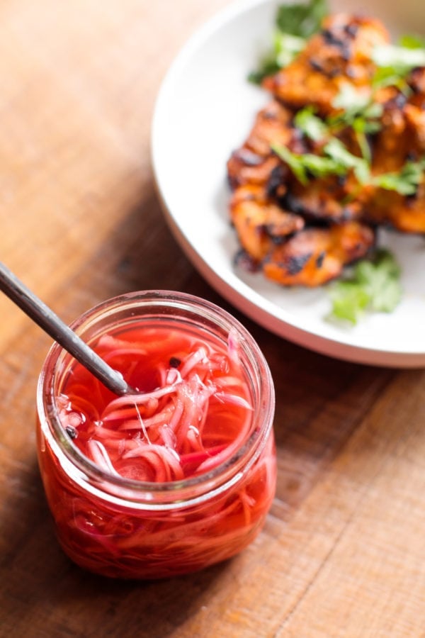 jar of pickled red onions and plate of chicken