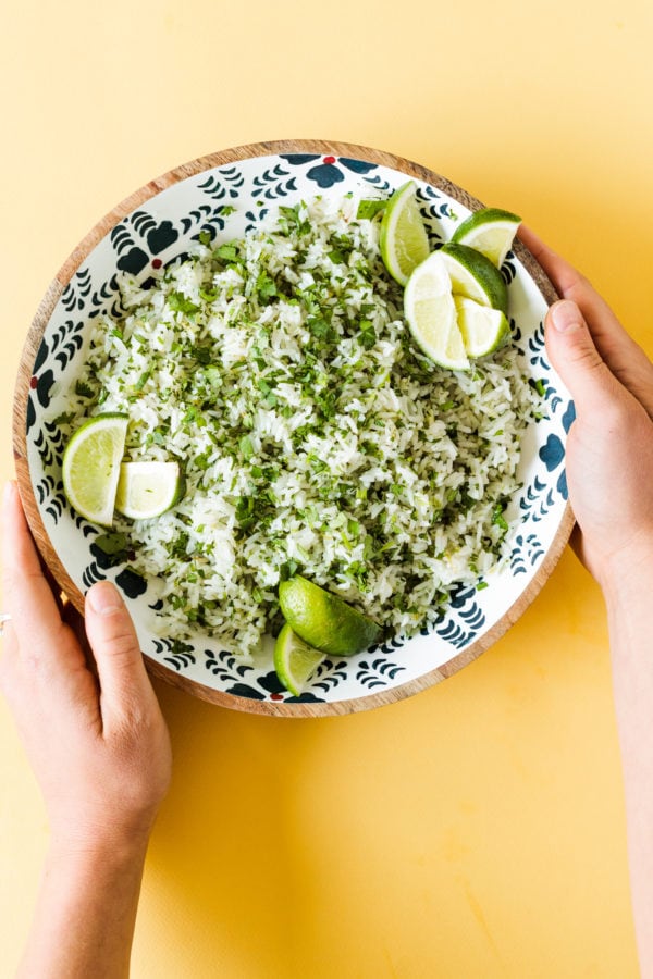 2 hands holding bowl of Cilantro Lime Coconut Water Rice