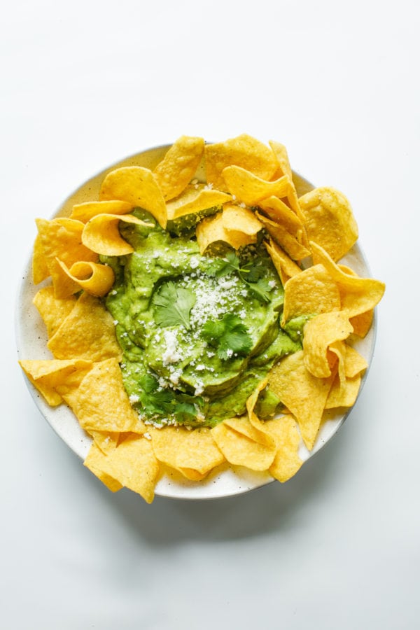 round platter of chips with Best Avocado Salsa Verde