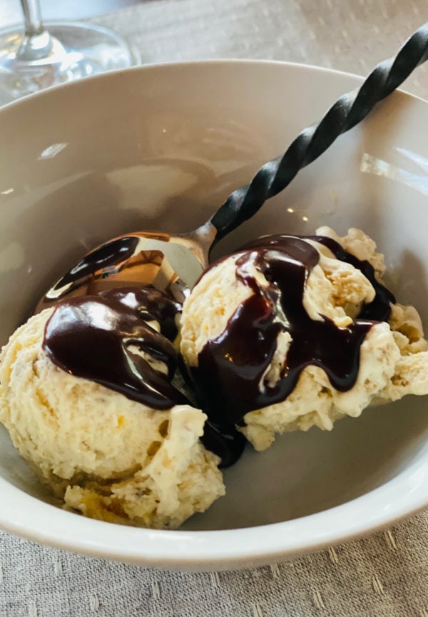 bowl of 2 scoops of banana ice cream with hot fudge