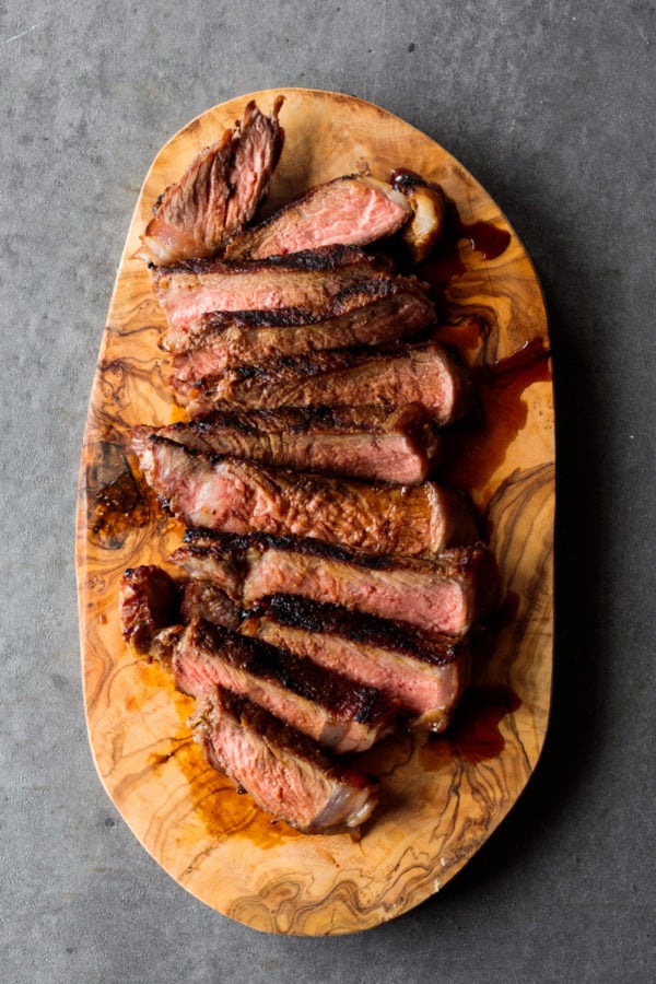 slices of Miso Marinated New York Steak on wood plate