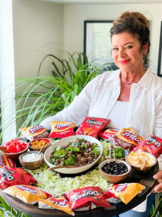 a woman holding an Epic Walking Taco Board