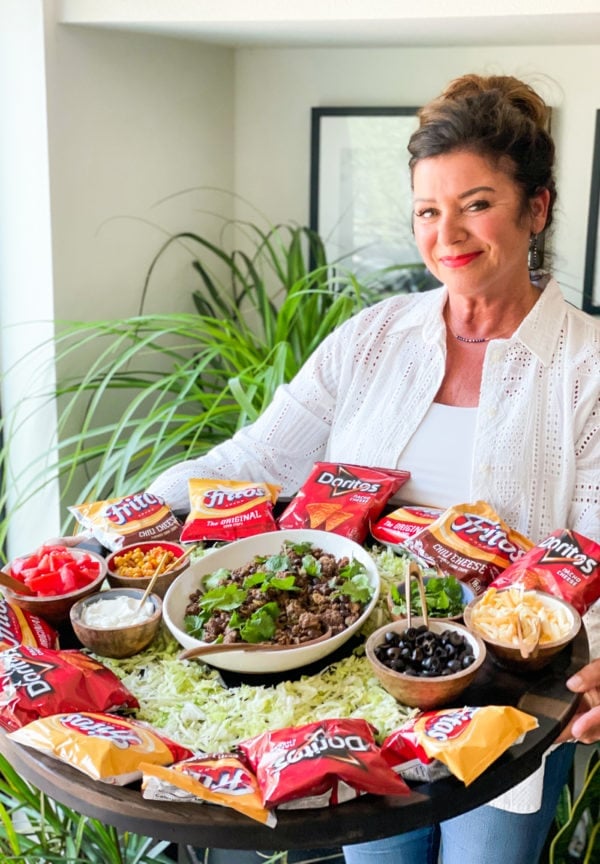 a woman holding an Epic Walking Taco Board