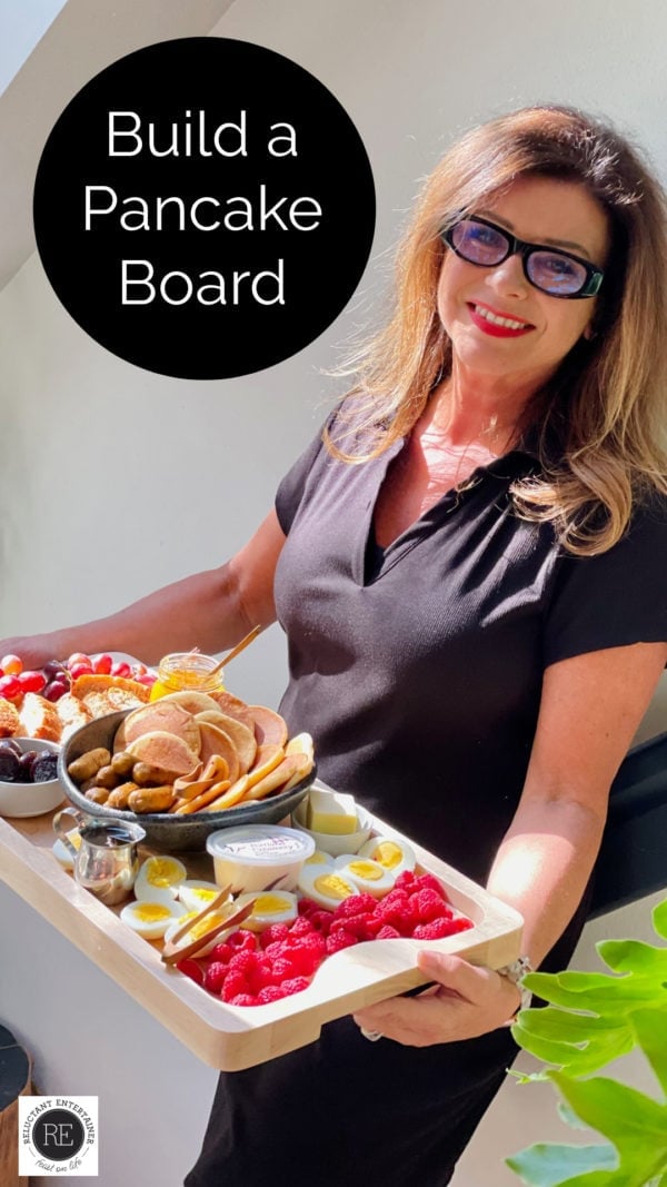 woman holding a big board with pancake breakfast