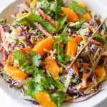 bowl of Crunchy Cashew Cabbage Salad with tongs