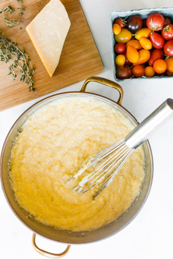 stirring a pot of Cheesy Garlic Polenta