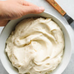 holding a bowl of Cream Cheese Mascarpone Frosting